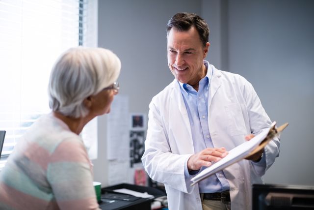 Medical professional engaging in a friendly conversation with a senior patient in a clinic. Ideal for use in healthcare articles, medical websites, patient care brochures, and advertisements focusing on senior health and doctor-patient relationships.