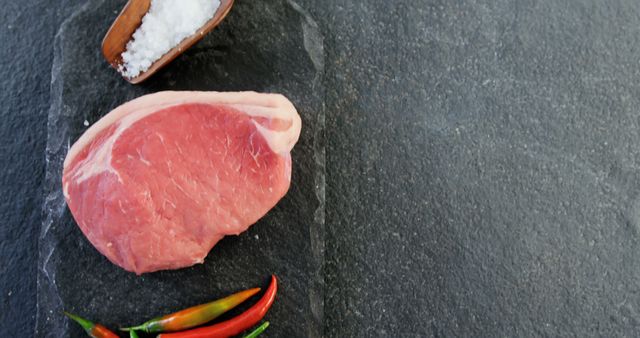 Raw Beef Steak with Sea Salt and Chili Peppers on Slate Background - Download Free Stock Images Pikwizard.com