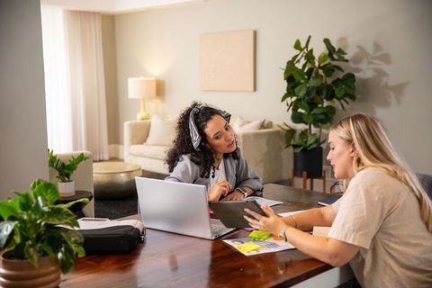 Professional Female Coworkers Analyzing Data in Home Office