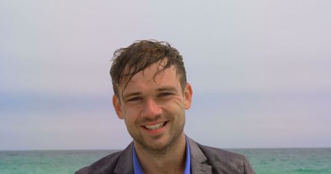 Businessman Smiling in Suit by Ocean Shoreline