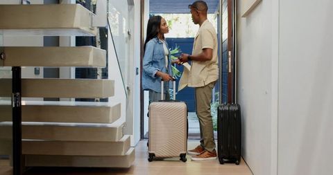 Couple Packing for Trip Near Modern Staircase