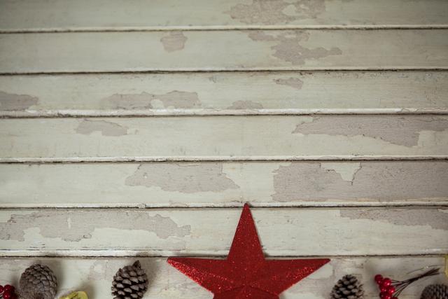 Rustic Christmas star decoration with pine cones on weathered wooden plank background. Ideal for holiday greeting cards, festive invitations, seasonal advertisements, and winter-themed decor inspiration.