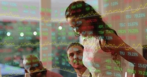 Female leader presenting stock market data on glass wall with collaborative team
