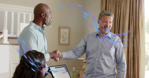 Mature professionals shaking hands in home meeting showing friendly business agreement