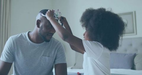 Daughter Crowning Father in Family Bonding Moment