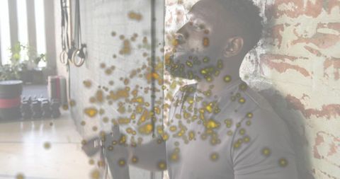 Leaning athlete catching breath after cable workout against exposed brick wall