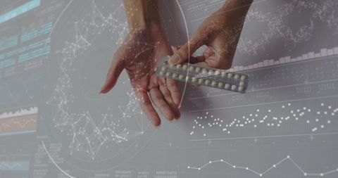 Hands holding pills with digital data interface in laboratory