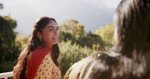 Smiling Woman in Traditional Attire Enjoying Outdoor Conversation