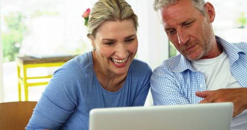 Happy Mature Couple Laughing Together Using Laptop at Home - Download Free Stock Images Pikwizard.com
