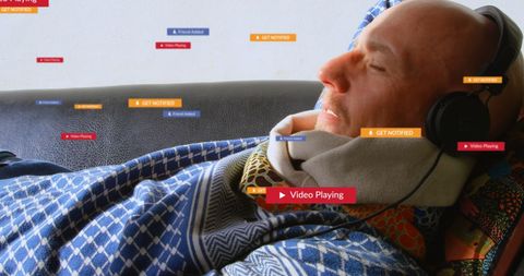 Senior man using social media on couch with headphones