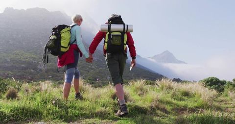 Senior Couple Hiking in Mountain Meadow on Sunny Day