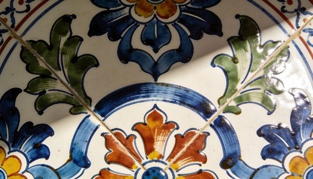 Hand-painted glazed ceramic tile featuring cobalt blue floral medallion and diagonal grout