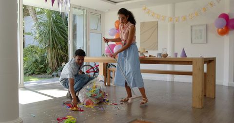 Couple Tidying Up After Festive Celebration at Home