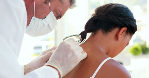 Doctor Conducting Thorough Back Exam on Patient