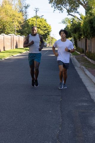 Diverse Friends Running on Suburban Road Embracing Fitness
