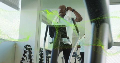 Senior Man Exercising with Towel on Treadmill in Gym