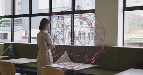 Asian Woman Engaged with Smartphone in Urban Cafe Setting