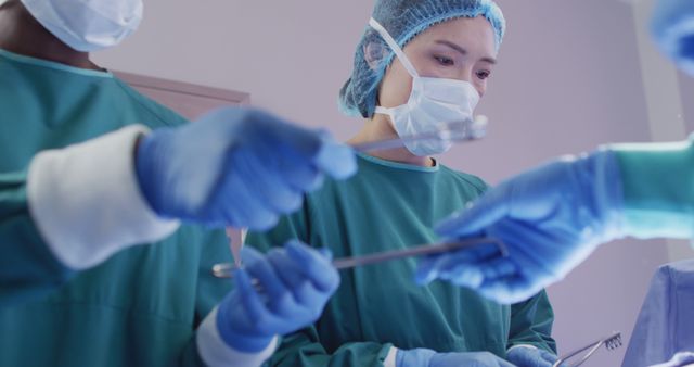 Asian female surgeon operates with assistance in a medical theater. - Download Free Stock Photos Pikwizard.com