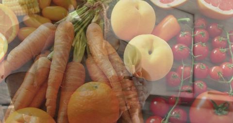Hands presenting fresh carrots, cherry tomatoes and citrus on rustic market crates