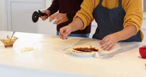Couple preparing homemade pie together in bright modern kitchen