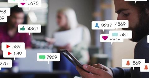 Man checking social media notifications on smartphone in modern coworking space