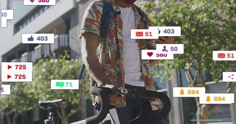 Urban cyclist checking smartphone with social media notifications and commuter bicycle