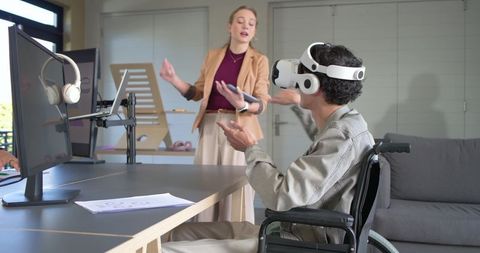 Inclusive team testing VR accessibility with wheelchair participant wearing headset in office