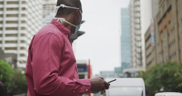 Man Wearing Face Mask Holding Smartphone in Urban Area - Download Free Stock Images Pikwizard.com