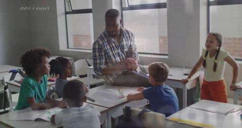Leading Hands-On Classroom Lesson with Engaged Primary Students Collaborating at Desks