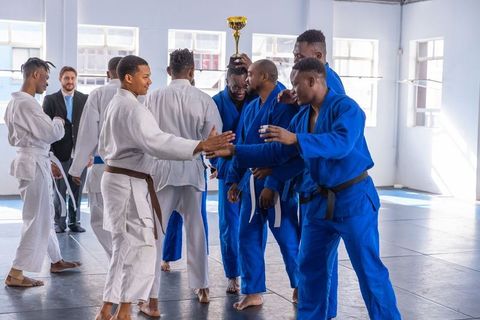 Martial artists celebrating victory with trophy in dojo