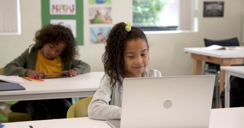 Students in Classroom Using Laptop and Tablet for Learning