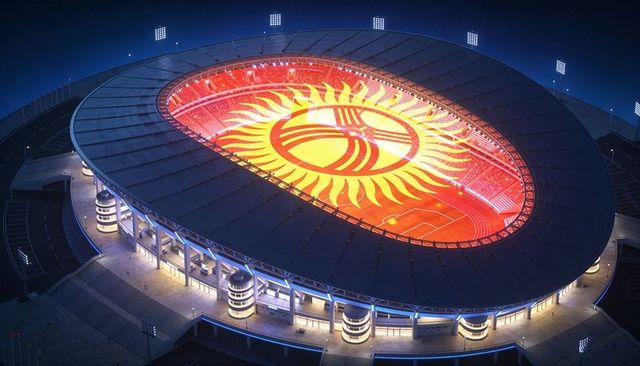 Aerial night view of oval stadium illuminating giant sun emblem on football field