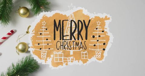 Handlettered merry christmas watercolor cutout with evergreen sprigs and gold baubles