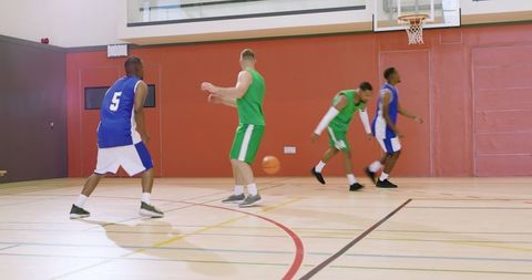 African american player driving to hoop while defenders contest rebound in indoor gym