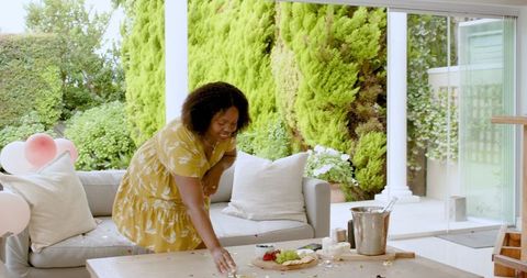 Joyful Woman Arranging Snacks on an Outdoor Patio