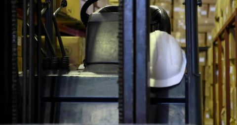 Forklift operator station with hard hat in warehouse storage area