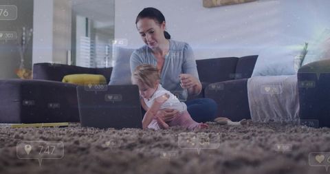Mother holding baby using laptop with social media metrics overlay in sunlit living room