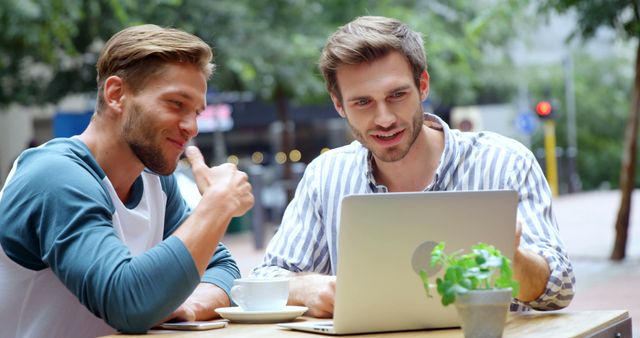 Two Young Men Collaborating at Outdoor Cafe on Laptop - Download Free Stock Images Pikwizard.com