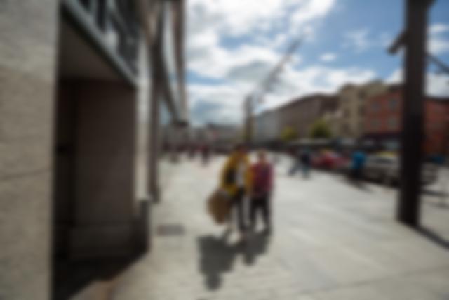 Blurred view of pedestrians walking on a city street on a sunny day. Suitable for concepts related to urban lifestyle, daily commute, city life, travel, and tourism. Can be used in articles, blogs, and advertisements focusing on urban environments and outdoor activities.