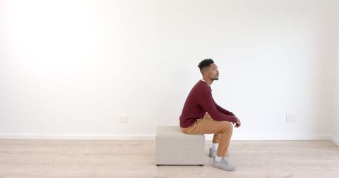 Man in Casual Outfit Sitting in Minimalist Living Room