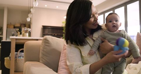 Mother Bonding with Infant Holding Toy in Modern Cozy Home Environment
