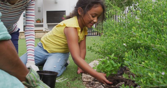 Hispanic girl with parents learning planting flowers in the garden. at home in isolation during quarantine lockdown.