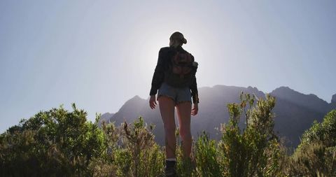 Female Hiker Exploring Refreshing Sunlit Ridge in Wilderness