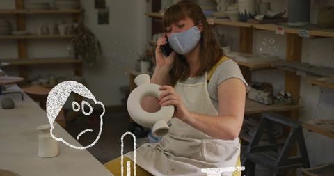Masked artisan working on ceramics amid covid-19 precautions