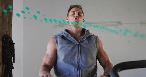Muscular man exhaling while running on treadmill with teal droplet motion graphic