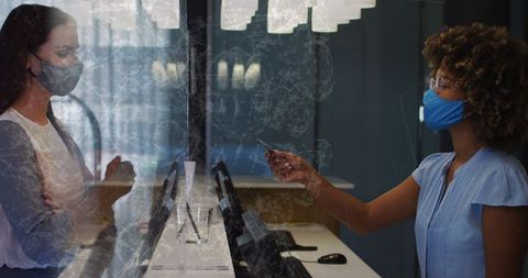 Receptionist assisting guest, covid-19 safety measures in office