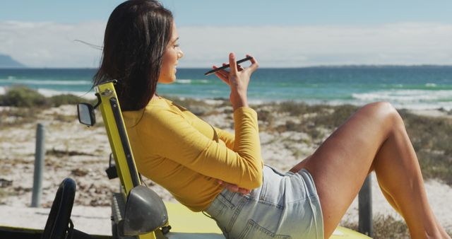 Caucasian woman lying on a beach buggy by the sea talking on smartphone - Download Free Stock Photos Pikwizard.com