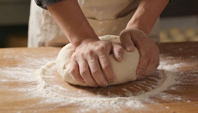 Kneading Dough with Hands on Floured Wooden Countertop for Rustic Homemade Bread Artisan Technique