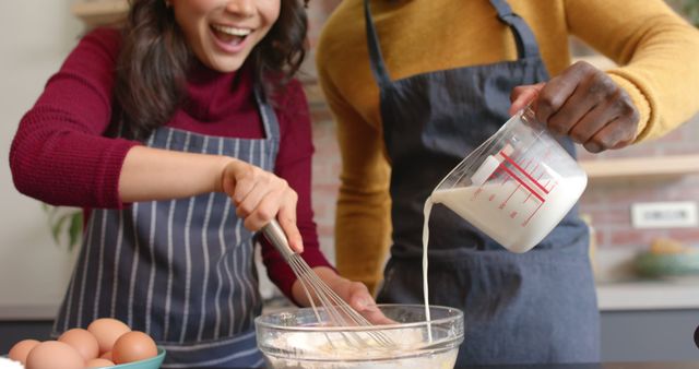 Smiling couple mixing ingredients in kitchen for baking session - Download Free Stock Images Pikwizard.com