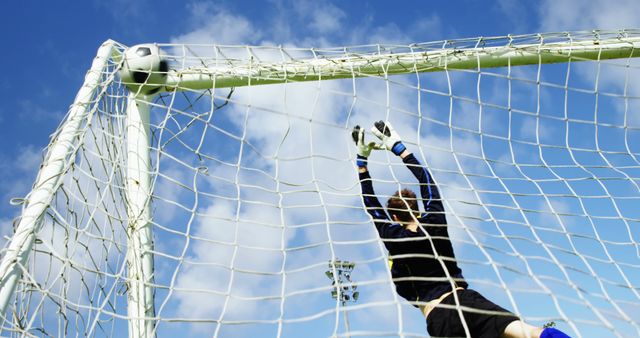 Goalkeeper Trying to Save Soccer Ball in Net Under Blue Sky - Download Free Stock Images Pikwizard.com